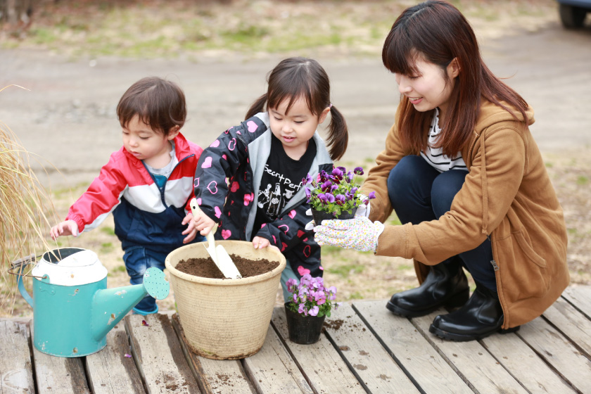 植木鉢に土を入れて花を植える親子