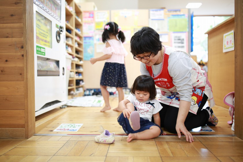 子育てひろばの入り口で靴を脱ぐ子ども