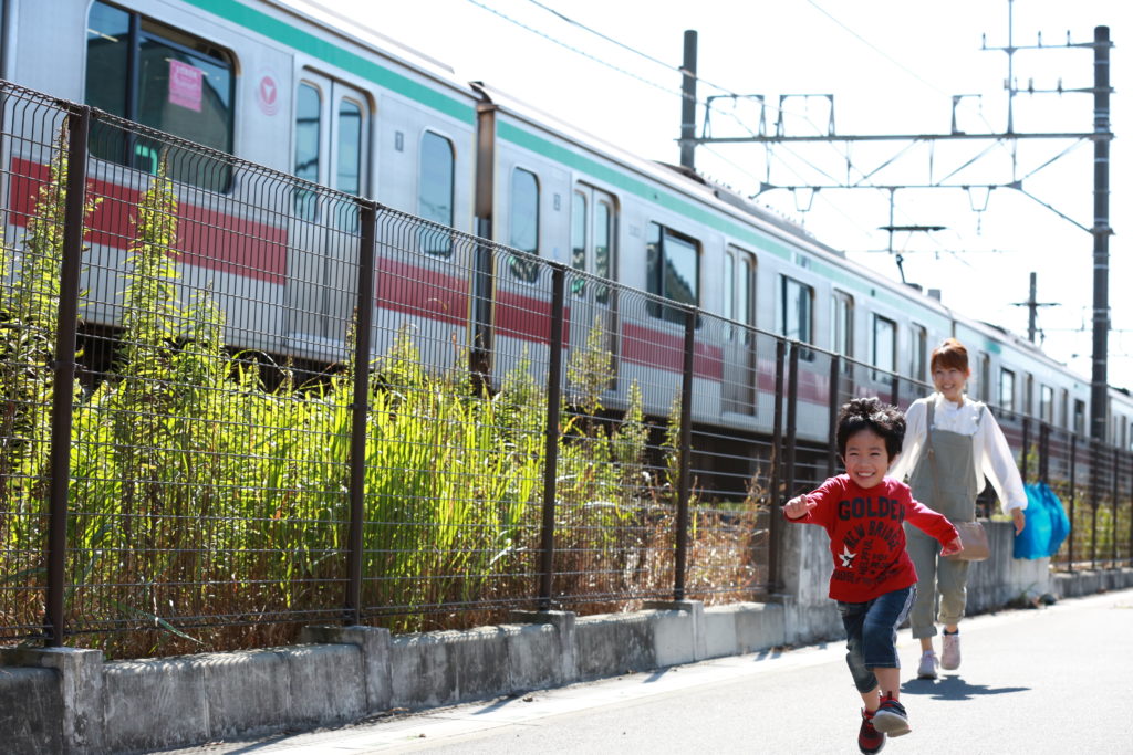 電車とおいかけっこする親子