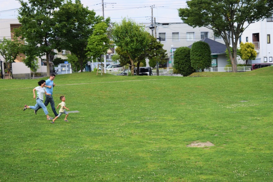 進修館の草原で駆ける親子