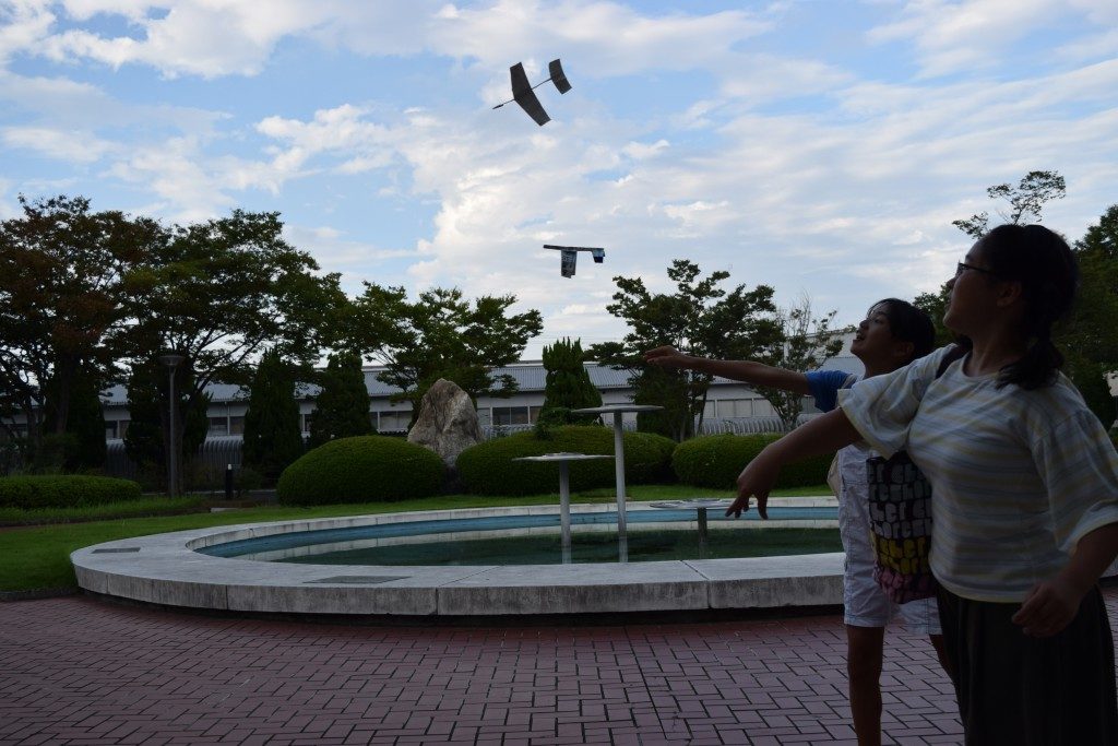 紙飛行機を飛ばす少女