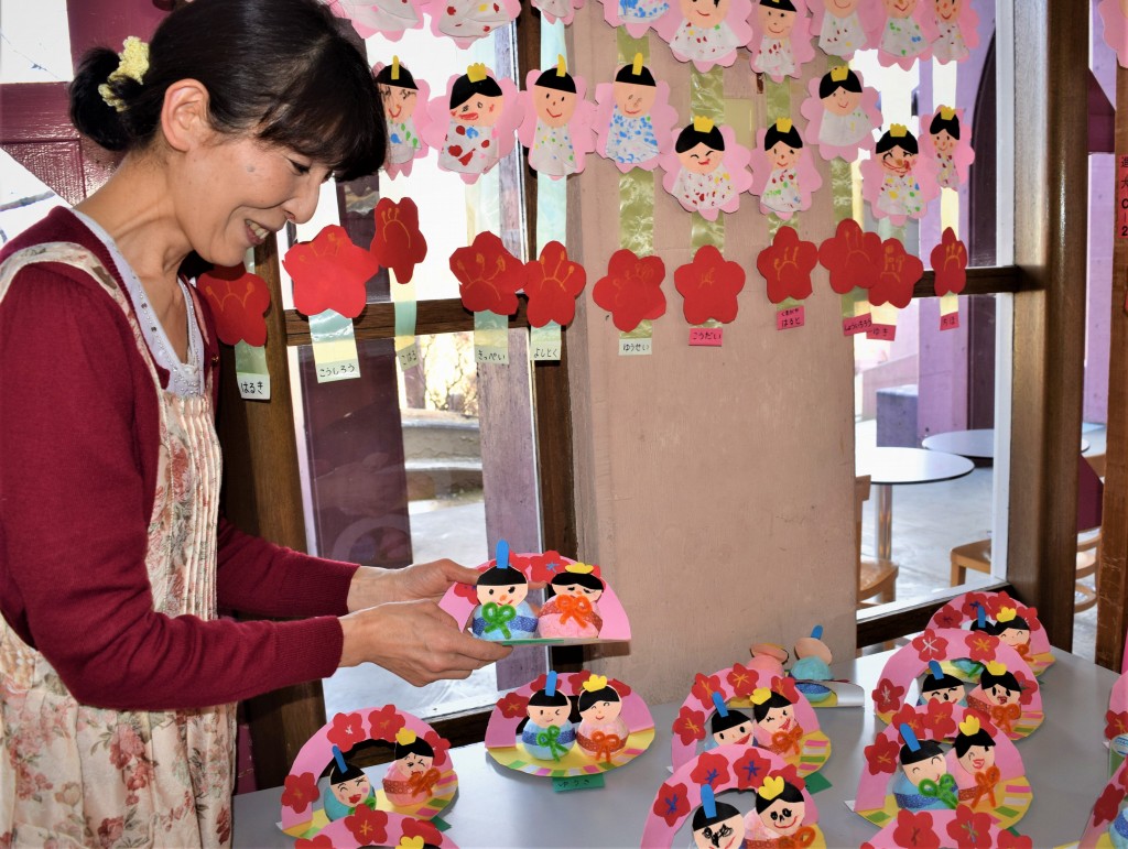 子どもたちの作品を手にする小川さん