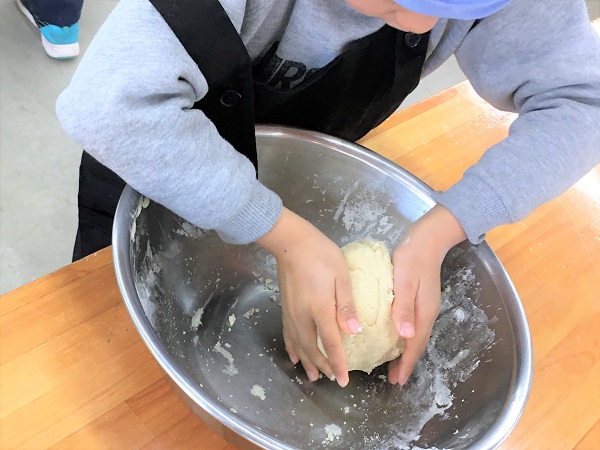 生地を手でこねている小学生の手元