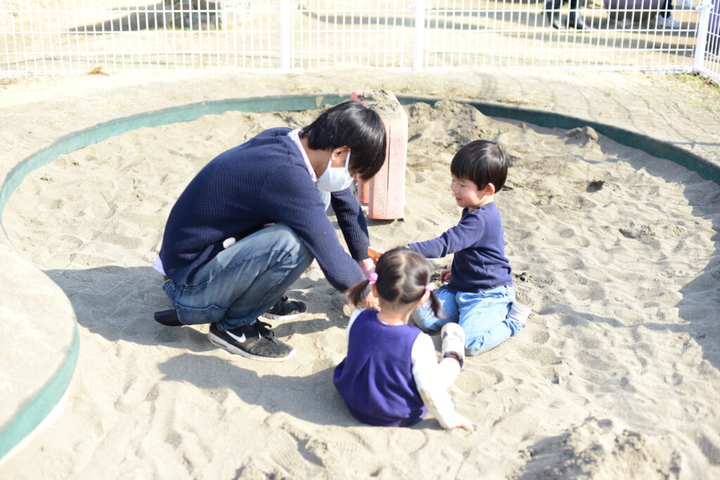 砂場で遊ぶ親子