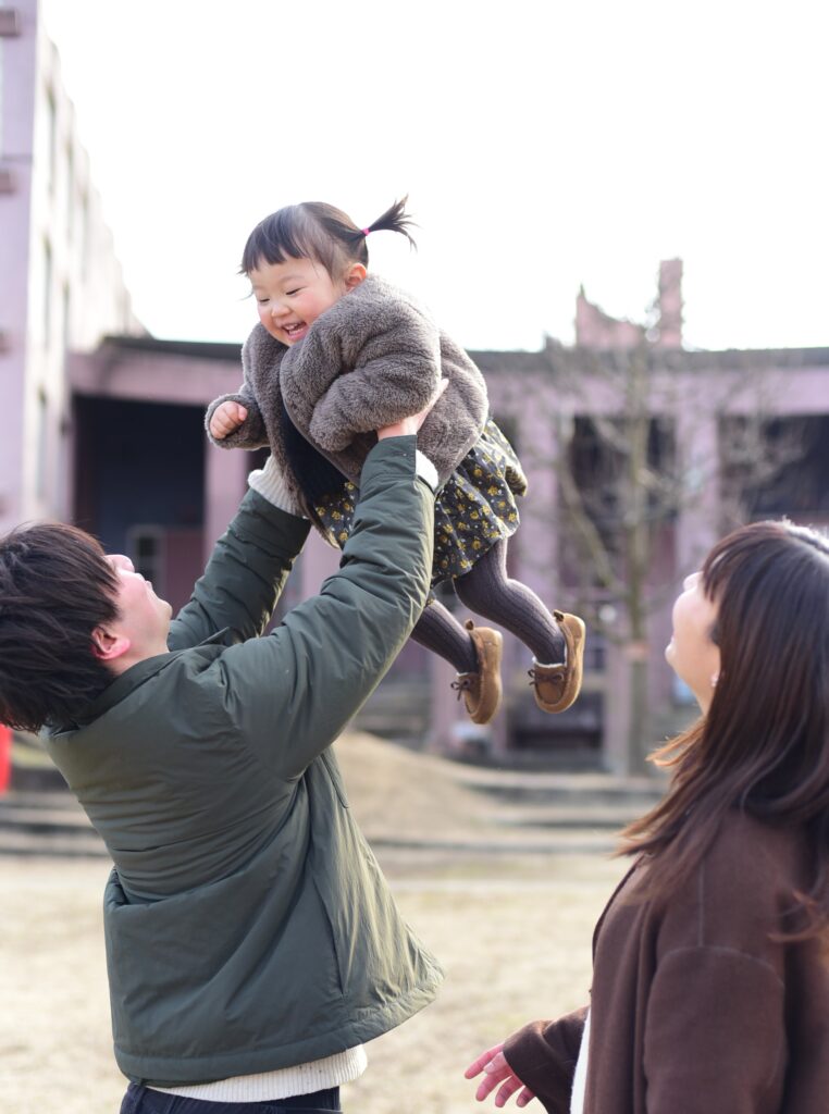 進修館の前で子どもと遊ぶ野内さんファミリー