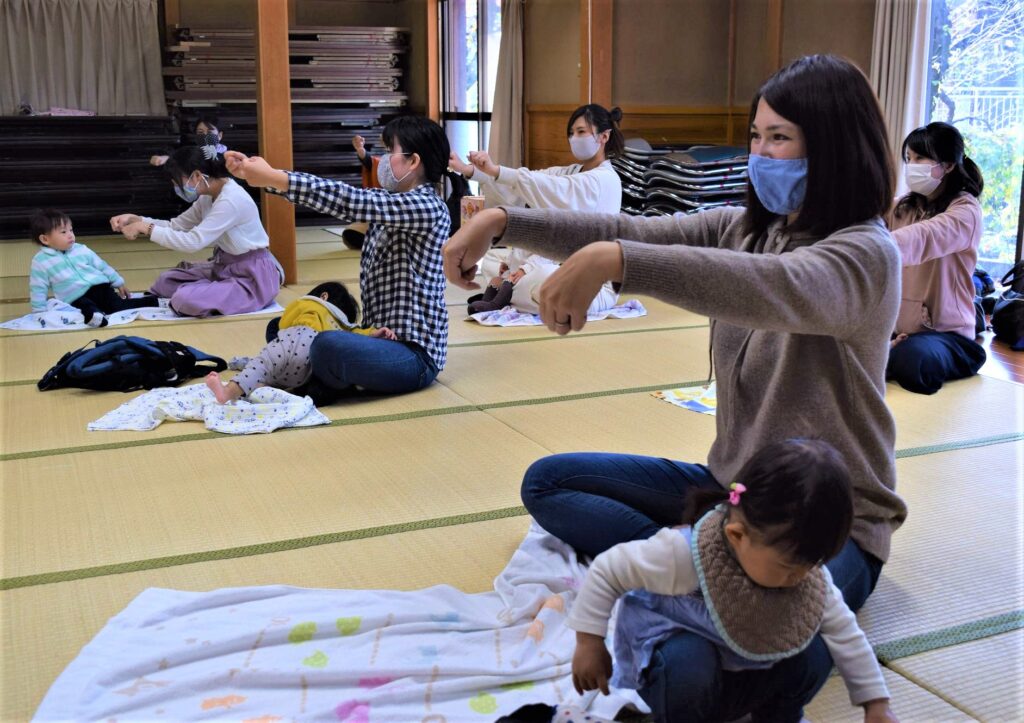 地域子育てサロンで親子で体操をする様子