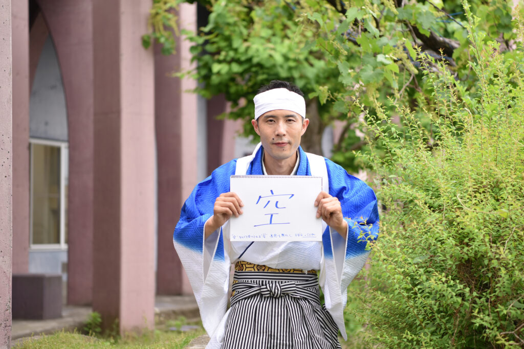 「空」と書かれた紙を持つ峰村さん
